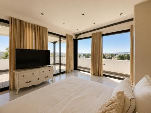 a large bedroom with a television and large windows at Villa Solis Elegant Villa with Private Pool in La Marsa +12 photos