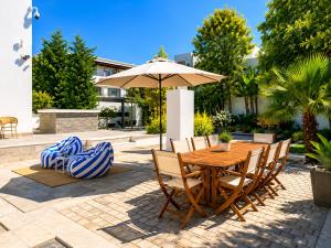 a wooden table and chairs with an umbrella at Villa Solis Elegant Villa with Private Pool in La Marsa