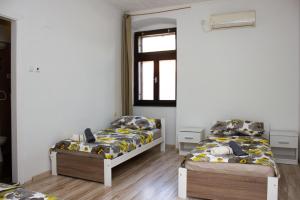 ein Zimmer mit zwei Betten und einem Fenster in der Unterkunft Hostel Centuria in Pula + 8 Fotos