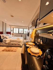 a bedroom with a bed and a table with plates on it at Flat Manaira Apart Hotel 1605 in João Pessoa +6 photos