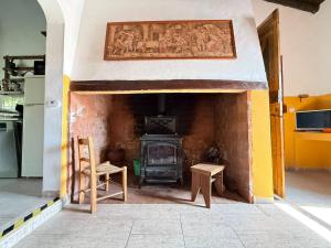 a kitchen with a brick fireplace and a stove at Solar Verbena in Vaiamonte