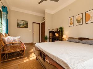 a bedroom with a bed and a chair at Sai Vatika Salbari Stays in Siliguri
