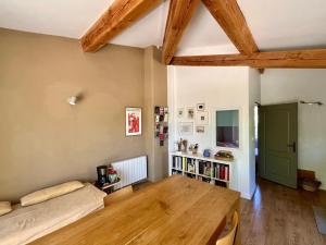 a living room with a wooden table and a couch at Les Iris in Bonnieux