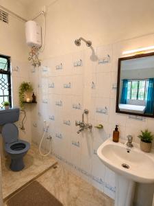 a bathroom with a toilet and a sink at Sai Vatika Salbari Stays in Siliguri