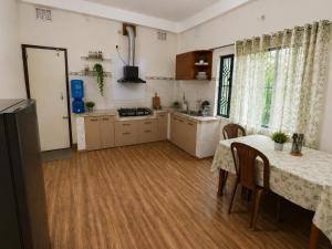 a kitchen with a table and a kitchen with a table and chairs at Sai Vatika Salbari Stays in Siliguri