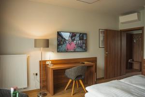 a bedroom with a desk and a bed and a tv on the wall at Penzión Skalica in Skalica
