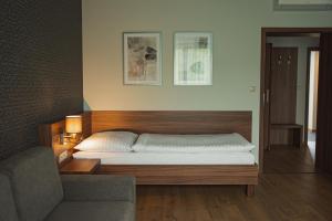a bedroom with a bed and a couch in a room at Penzión Skalica in Skalica