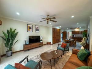 a living room with a couch and a tv and a table at View Talay Longstay Hotel & Suites in Jomtien Beach