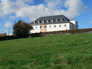 uma casa branca no topo de uma colina relvada em Gîte Kaleo Eupen Jugendherberge em Eupen