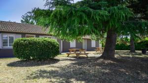 a picnic table and a tree in front of a house at Campanile NATURE - Bollene in Bollène