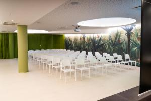 a room with rows of white chairs and a mural at Camping Village Garden Paradiso in Cavallino-Treporti +97 photos