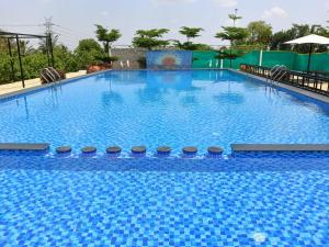 a large swimming pool with blue water at Nenapu Resorts in Oddarahalli