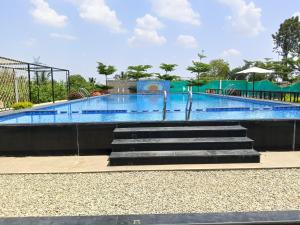 a large swimming pool with stairs in it at Nenapu Resorts in Oddarahalli