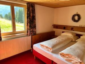 a bedroom with two beds and a window at Appartements Birkenhof in Lech am Arlberg