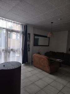 a living room with a couch and a table at Un petit coin de paradis in Gavarret