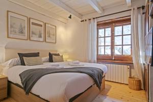 a bedroom with a large bed and a window at Luderna - Apartamento con terraza Eth Picot in Tredós