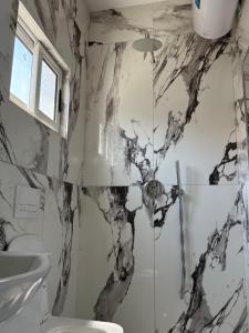 a bathroom with a black and white marble wall at Rezidenca Inspire in Tirana +15 photos