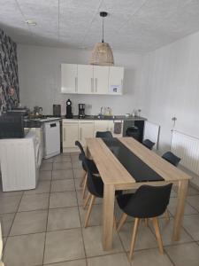 a kitchen with a wooden table and chairs at Un petit coin de paradis in Gavarret +7 photos