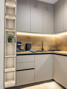 a kitchen with white cabinets and a sink at 2BР Apartment in a Modern Complex in Plovdiv