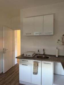 a kitchen with white cabinets and a sink at Apartment Rotenburg in Rotenburg an der Fulda +17 photos