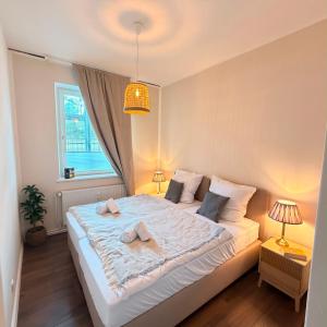 a bedroom with a large white bed with two pillows at HYGGE HOMES Apartment - 'nordlys' in Lüneburg