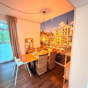 a dining room with a table and chairs and a painting at HYGGE HOMES Apartment - 'nordlys' in Lüneburg