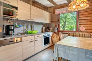 a kitchen with wooden cabinets and a table and a window at Ferienwohnung Rihm in Arrach