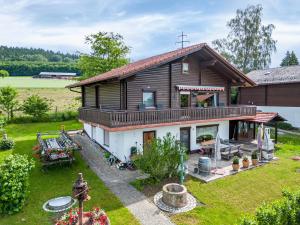 a large wooden house with a porch and a yard at Ferienwohnung Rihm in Arrach