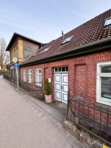 a red brick building with white doors on a street at HYGGE HOMES Apartment - 'nordlys' in Lüneburg
