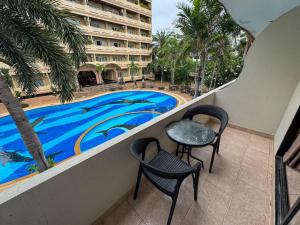a balcony with a table and chairs and a swimming pool at View Talay Longstay Hotel & Suites in Jomtien Beach