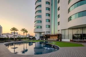 a building with a pool in front of a building at A-ONE Bangkok Hotel in Bangkok