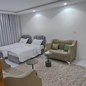 a bedroom with a bed and a couch at شقق غرفتين جديدة واسعة in Musaylah