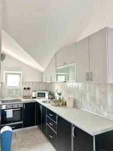 a kitchen with white cabinets and a counter top at SeaSide Holiday Apartment in Bijela