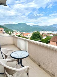 a table and chairs on a balcony with a view at SeaSide Holiday Apartment in Bijela