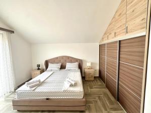 a bedroom with a bed with a wooden headboard at SeaSide Holiday Apartment in Bijela