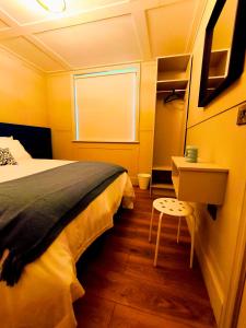 a bedroom with a bed and a table and a window at Canal View Lodge & Spa - Entire 3 Bed Lodge in Longford