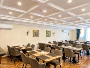 a dining room with tables and chairs in it at Silk Road Kokand Hotel in Kokand