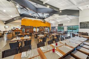 a dining room with wooden tables and chairs at Hôtel Restaurant Akena Bordeaux Sud - La Brède in La Brede