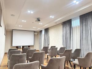 a room with chairs and a projection screen at Silk Road Kokand Hotel in Kokand