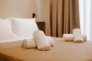 a group of rolled towels on top of a bed at MAHA Her City Living by Semavί in Heraklio