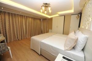 イスタンブールにあるRooms Inn Taximのベッドルーム(大きな白いベッド1台、シャンデリア付)