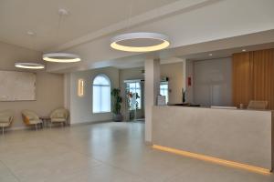 an empty lobby with a reception desk and chairs at Hotel Restaurante Glasgow in Villadesuso
