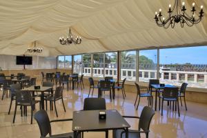 a dining area with tables and chairs in a tent at Hotel Restaurante Glasgow in Villadesuso