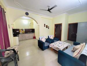 a living room with two blue couches and a table at 2BHK Flat in Bhimtal in Bhowāli