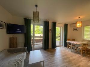 a living room with a table and a dining room at Przylądek Werlas in Werlas