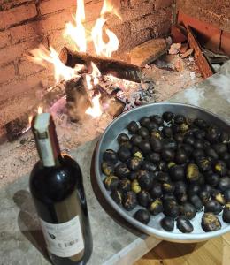 a bottle of wine next to a bowl of olives at Mirjana Guesthouse in Pukë +12 photos