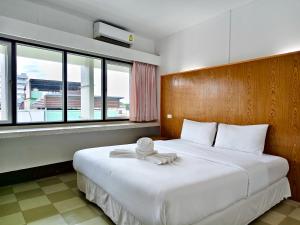 a bedroom with a large white bed with a large window at S2S Queen Trang Hotel in Trang