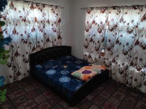 a bed in a room with curtains and a couch at Alpine Adventures Guest House Gurez in Gurais