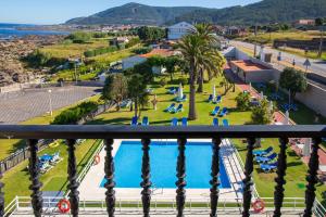 a view from the balcony of a resort with a swimming pool at Hotel Restaurante Glasgow in Villadesuso