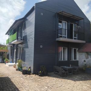 a black building with a bench in front of it at ULA guest house in Ureki